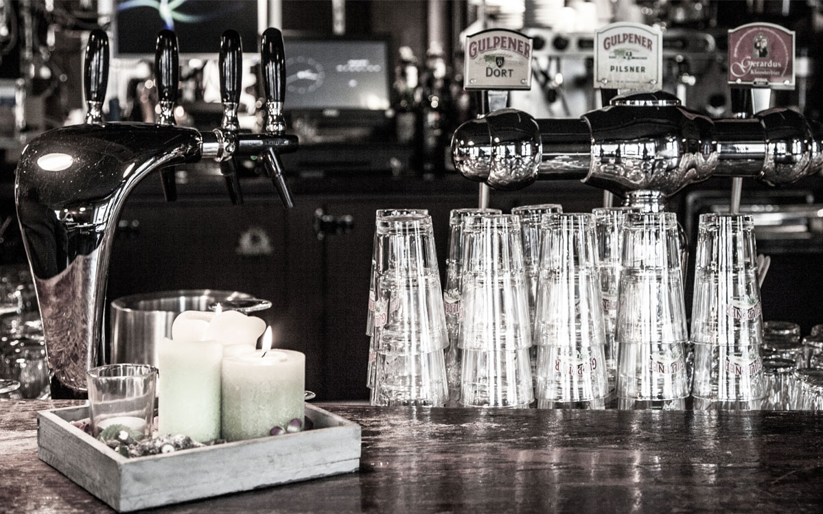 Bar van Café de Taverne met biertaps en kaarsen