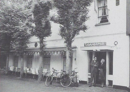 Café de Taverne in 1961, met luifel en gasten in de deuropening